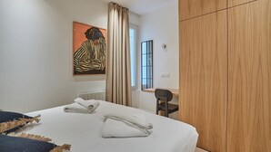 Ein modernes Hotelzimmer mit einem großen Bett, einem Schreibtisch und einem Kleiderschrank.