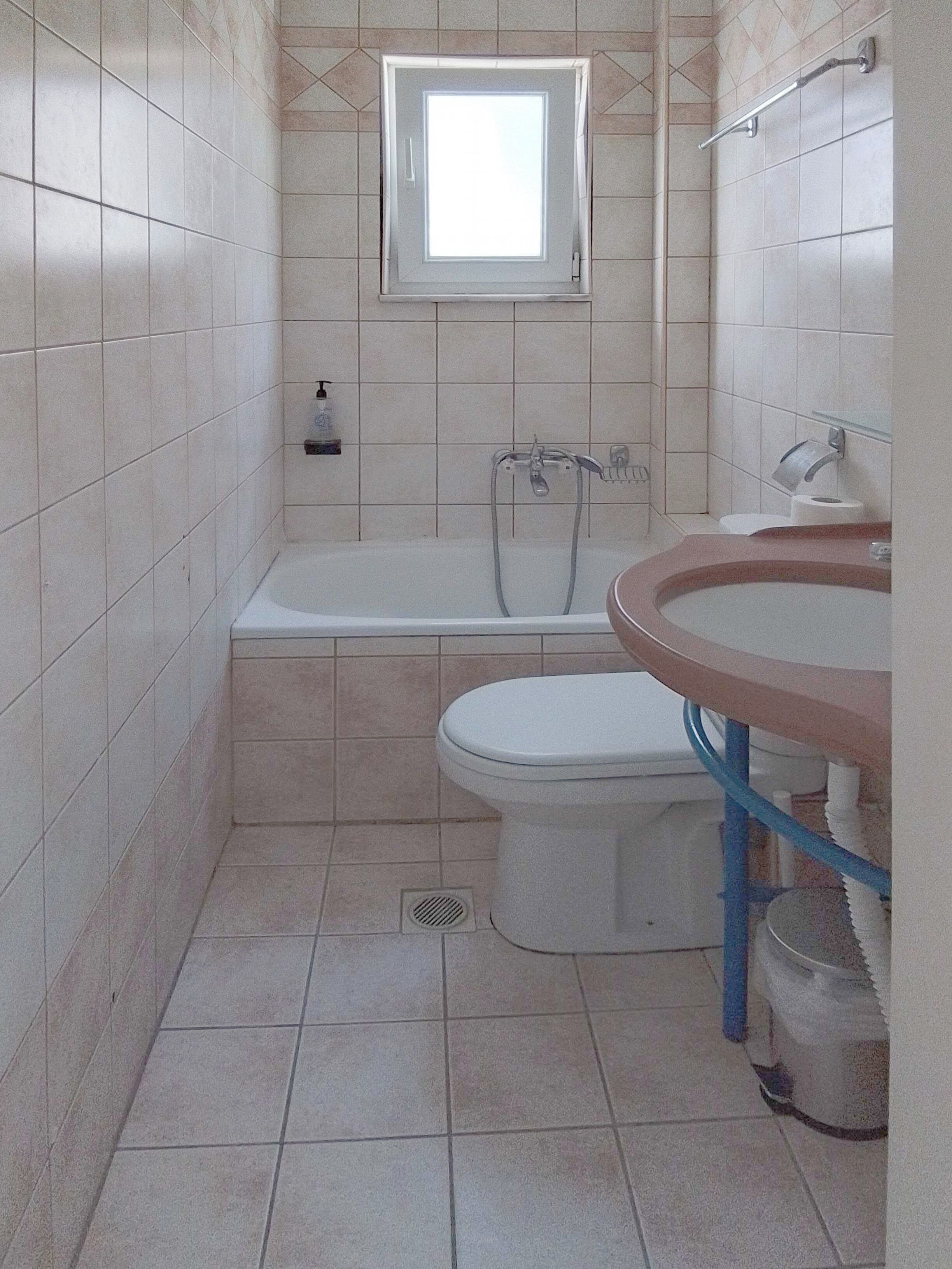 Ein kleines Badezimmer mit Toilette, Waschbecken und einer Badewanne.
