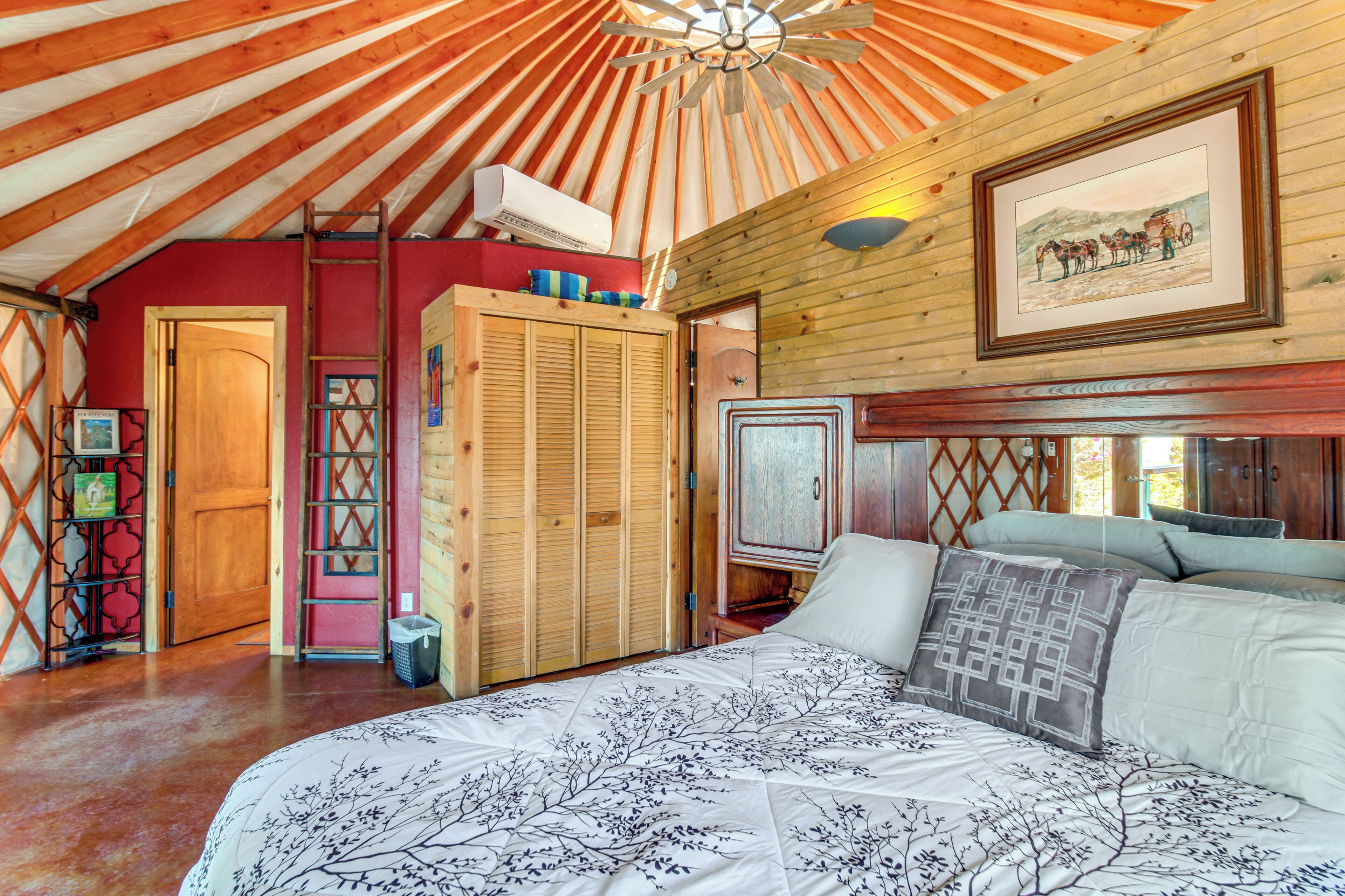 Una habitación acogedora con una cama grande, techo de madera y un cuadro colgado.