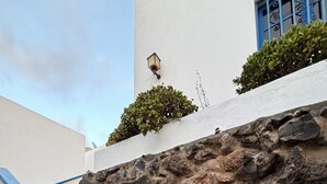 A staircase with blue handrails leading up to a stone wall.