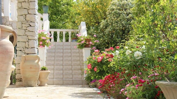 A stone pathway leading to a white gate, surrounded by lush greenery and flowering plants. - ROCABEL AUTHENTIC CHARM SOUTH-FACING PANORAMIC VIEW OF THE VALLEY AND SEA (Gattières)