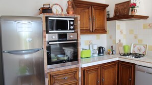 A kitchen with a refrigerator, microwave, oven, and a coffee maker. - ROCABEL AUTHENTIC CHARM SOUTH-FACING PANORAMIC VIEW OF THE VALLEY AND SEA (Gattières)