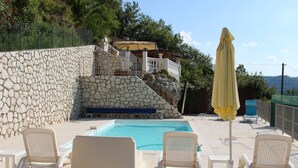 A poolside area with lounge chairs and a yellow umbrella. - ROCABEL AUTHENTIC CHARM SOUTH-FACING PANORAMIC VIEW OF THE VALLEY AND SEA (Gattières)