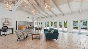 A spacious lobby with a high ceiling, modern furniture, and large windows.