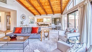 Un vaste espace de vie doté d’un haut plafond, d’un coin repas et de grandes fenêtres.