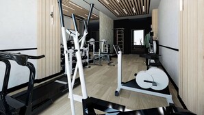 A modern gym with various exercise equipment, including a treadmill, weight machines, and a rowing machine.