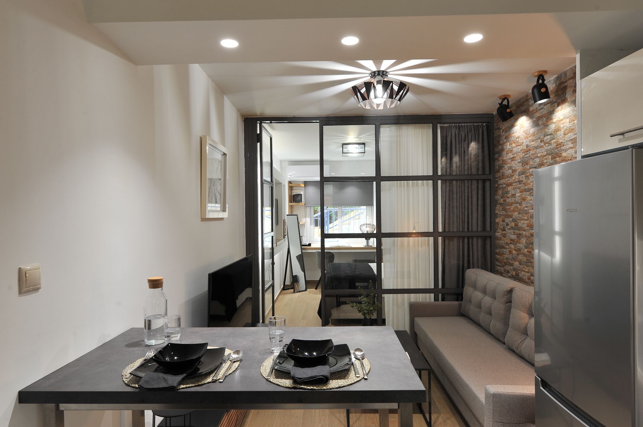 Una cocina moderna con comedor, sofá y refrigerador.