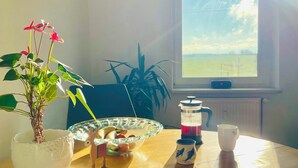 Une table à manger avec un bol blanc, une cafetière et une tasse.