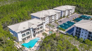 Ein mehrstöckiges Hotel mit Schwimmbad und Außenbereich zum Sitzen.