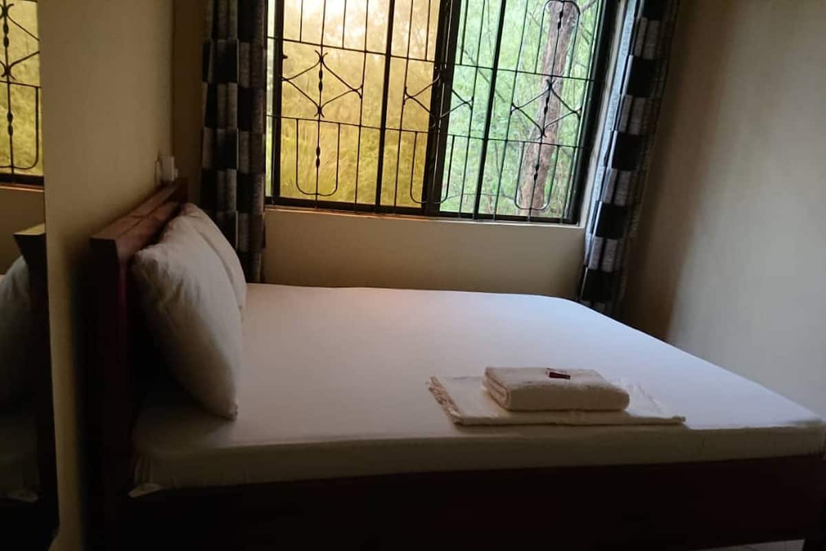 Una cama bien hecha con un colchón blanco y una toalla blanca doblada.