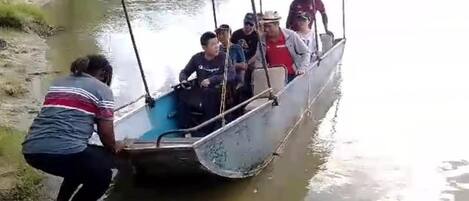 A group of people in a small boat on a river.