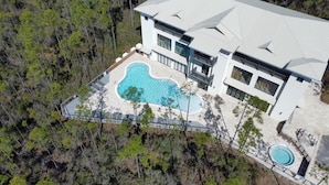 An aerial view of a modern house with a large swimming pool, surrounded by a forested area. - Pinewood30a 136 (Santa Rosa Beach)