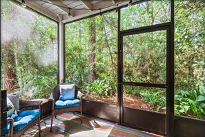 A room with a large window, wicker furniture, and a colorful rug. - 2br/2.5ba, Pool, Tennis, Beach Access! (Santa Rosa Beach)