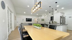 A modern kitchen with white cabinets, a central island, and a built-in oven. - Stardust Villa 4 Bedroom Home by RedAwning (Kissimmee)