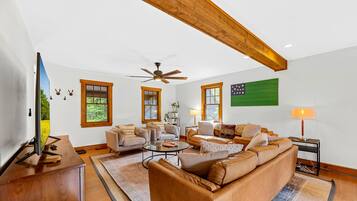 Relax in the spacious living room with a comfortable sofa, armchair, and flat-screen TV.