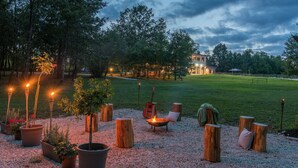A serene outdoor seating area with a fire pit, wooden stools, and potted plants. - Modern Villa Anima with swimming pool (Pazin)