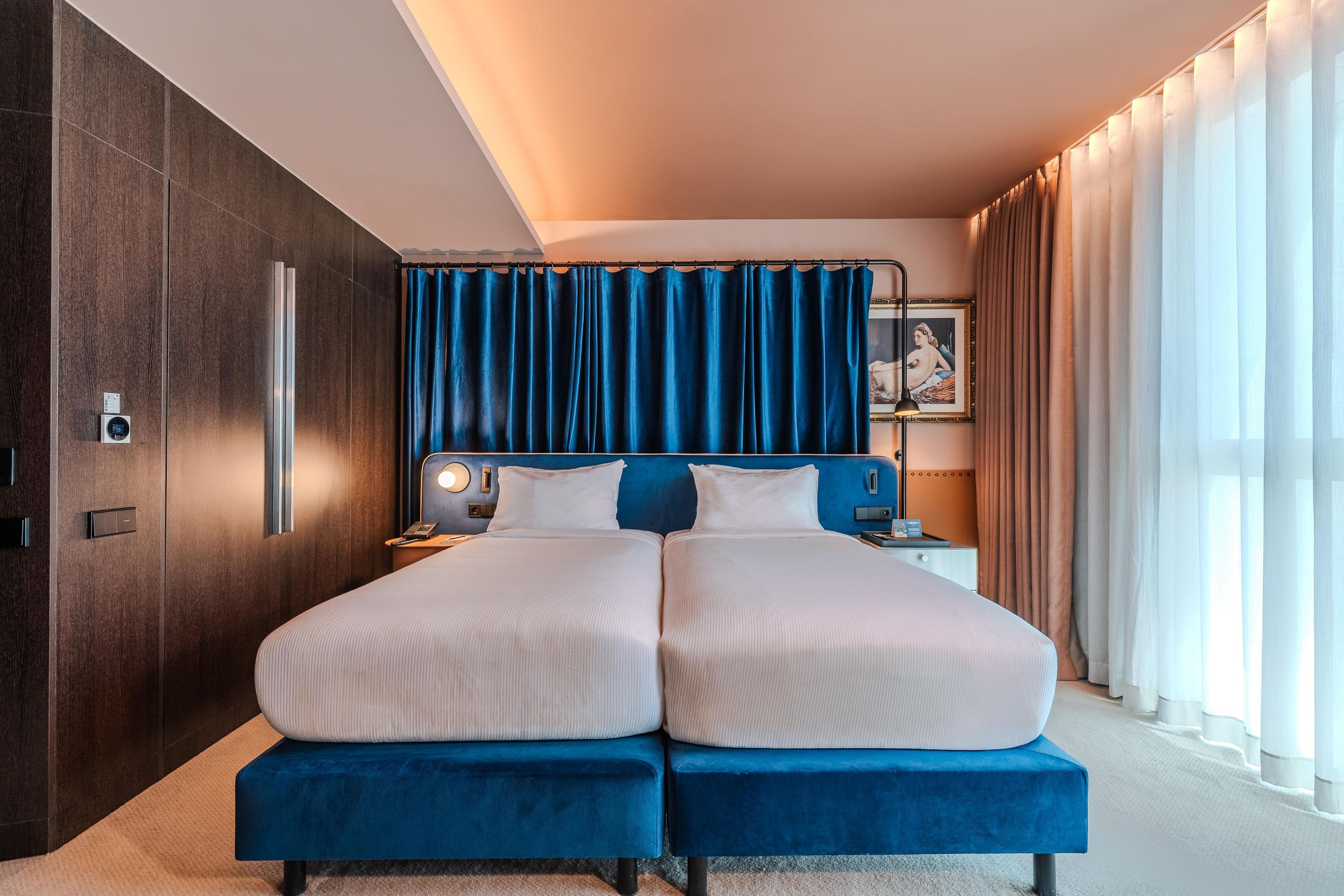 A double bed with a headboard, bedside tables, and a nightstand with a lamp.