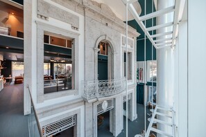 Ein modernes Interieur mit einer Stein-Fassade, einem Balkon mit aufwendiger Metallgeländer und Blick auf die Straße.