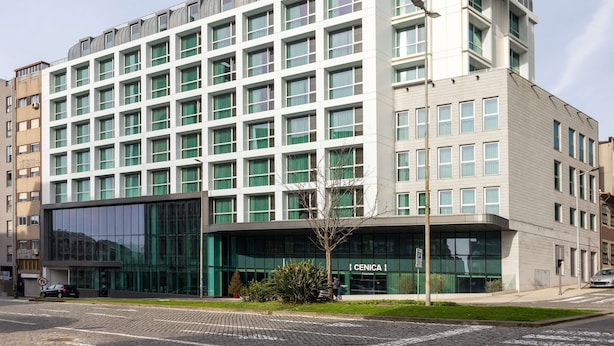 A modern building with a grid of windows, a glass facade, and a sign reading "CENICA."