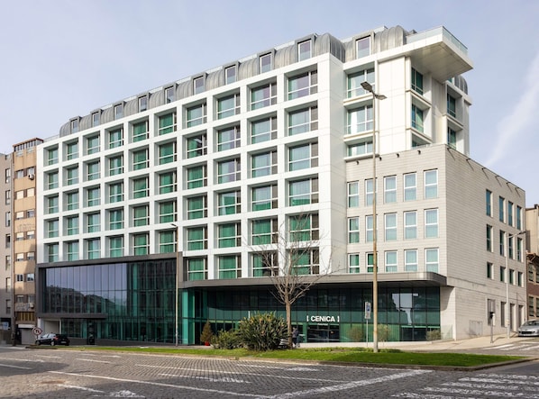 En moderne bygning med et vinduesgitter, en glasfacade og et skilt med teksten "CENICA".