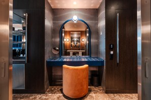 A modern bathroom with a vanity, mirror, and marble flooring.