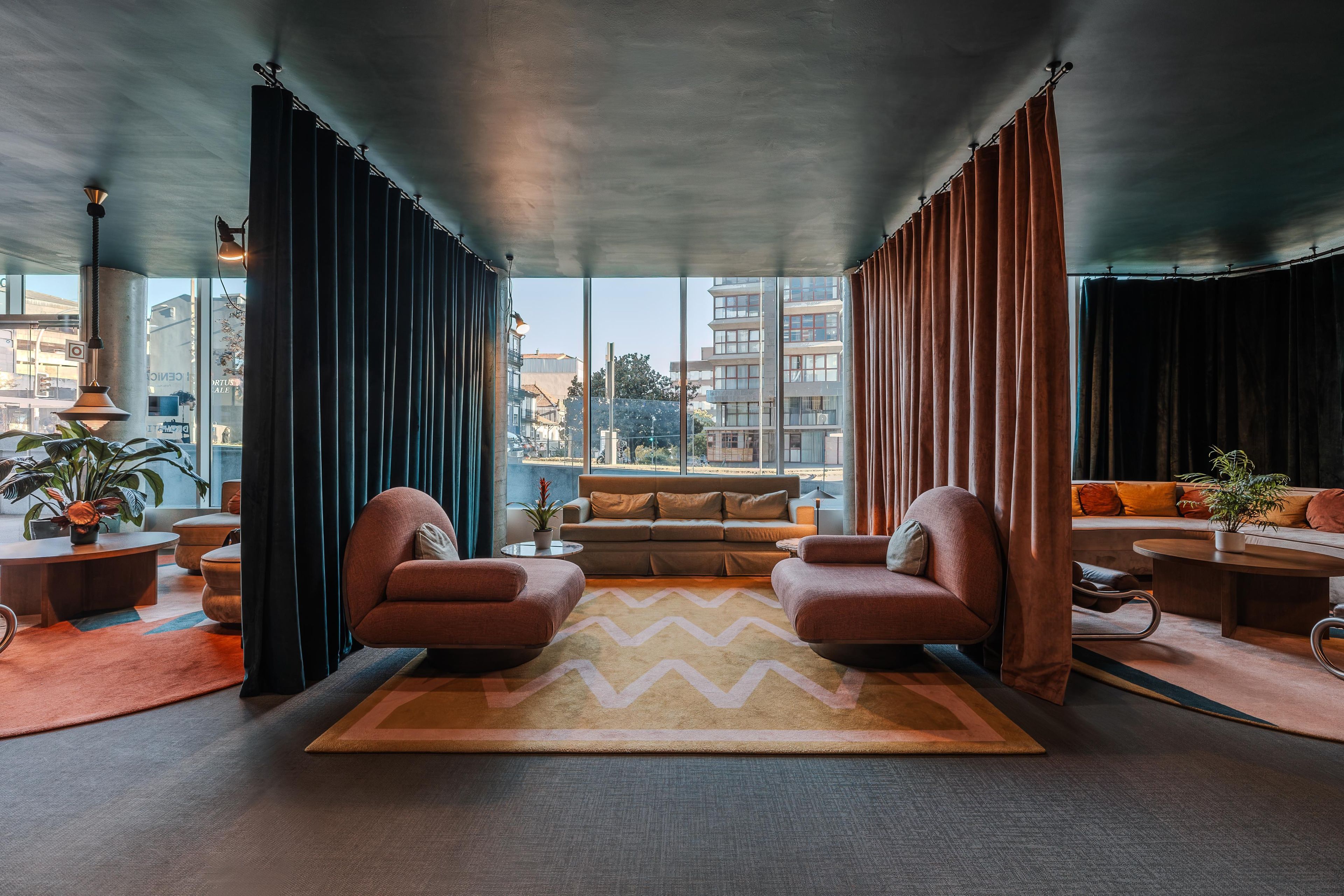 Una sala de estar moderna con un ventanal grande, un sofá, dos sillones y una mesa de centro.