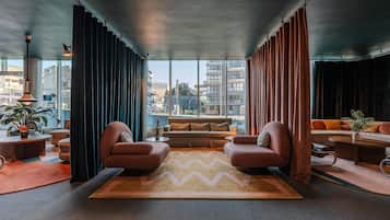 Una sala de estar moderna con un ventanal grande, un sofá, dos sillones y una mesa de centro.