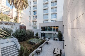 A courtyard with outdoor seating, a staircase, and a building with multiple windows. - Cenica Porto Hotel, Curio Collection by Hilton (Porto)