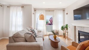 A living room with a sofa, armchair, and a fireplace. - Spacious 3B/2.5B Home in the Heart of Capitol Hill (Seattle)