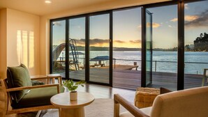 A modern room with large windows overlooking a waterfront. - 1BR 2BA Lower Unit with Lake Access - Prime Spot (Issaquah)