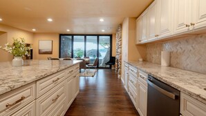 A modern kitchen with marble countertops, white cabinetry, and a view through the glass door. - 1BR 2BA Lower Unit with Lake Access - Prime Spot (Issaquah)
