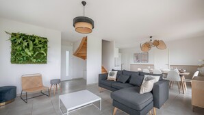A modern living room with a grey sectional sofa, a white coffee table, and a green wall decor. - 650m from the sea, modern house for 7 (Piriac-sur-Mer)