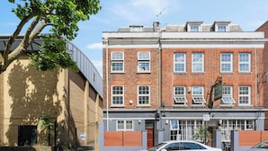 A two-story brick building with a white car parked in front. - King's Cross Boutique Apartment! ZONE 1 !!! (London)