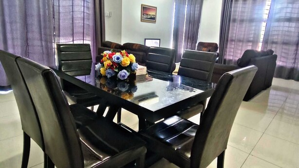 A dining area with a rectangular table surrounded by chairs, a ceiling fan, and curtains. - KLIA AIRPORT HOMESTAY 9 (Sepang)