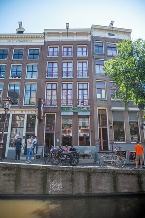 Un immeuble à plusieurs étages, doté d’une façade en briques, de grandes fenêtres et d’une devanture visible.
