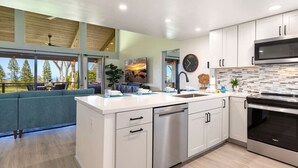 Una cocina moderna con armarios blancos, electrodomésticos de acero inoxidable y una isla grande.