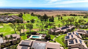 Un campo de golf con piscina y varios edificios equipados con paneles solares.