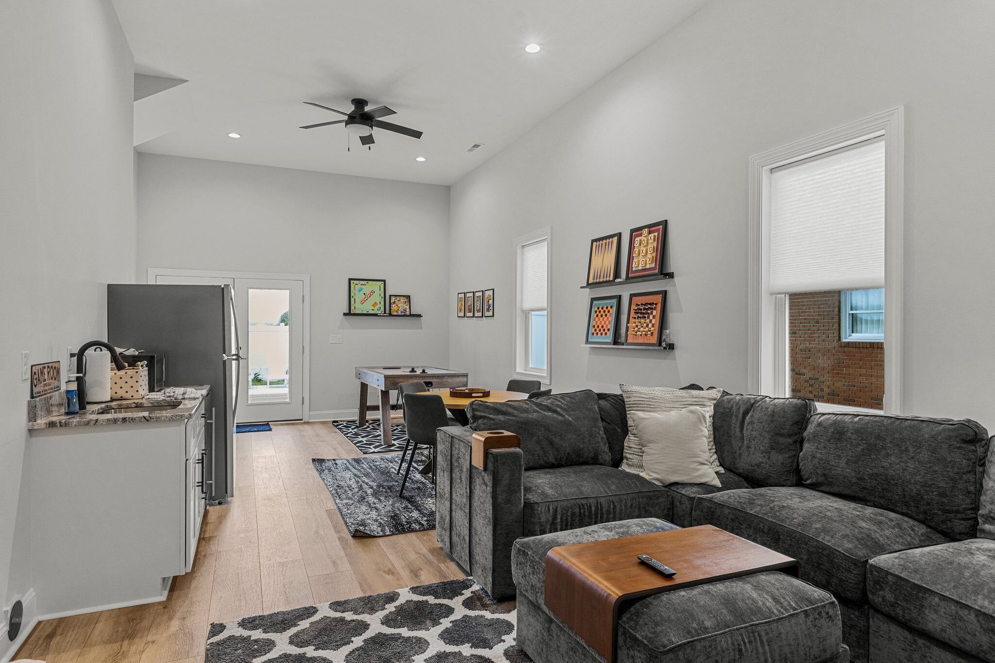 A modern living room with a gray sofa, a coffee table, and a dining area with a table and chairs.
