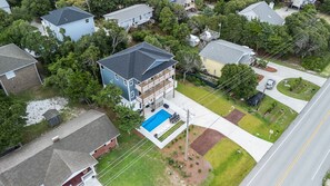 Two-story house with a second-floor balcony, lawn, and pool.