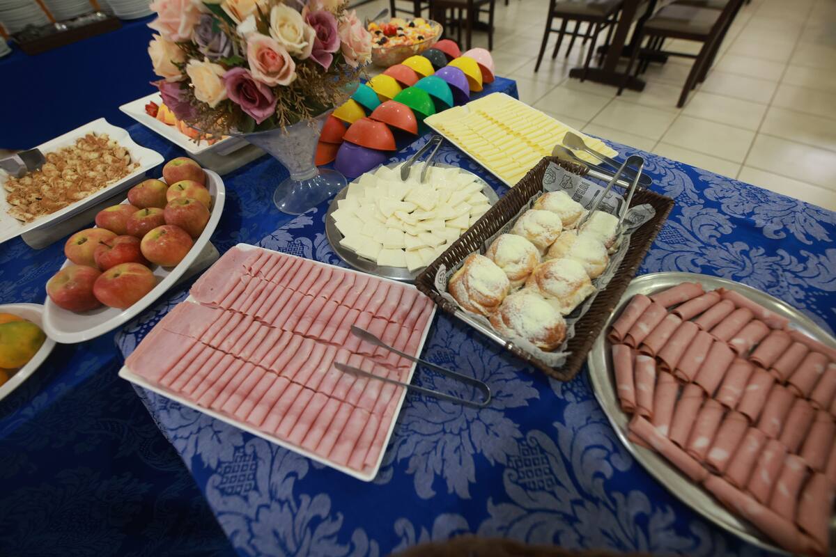 A buffet table with various food items including fruits, cheeses, and meats.