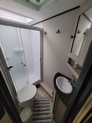 Een douche, handdoeken, zeep, toiletpapier