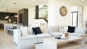 Un salon moderne comprenant un ensemble de canapés, une table basse et un coin repas avec des chaises et une table.