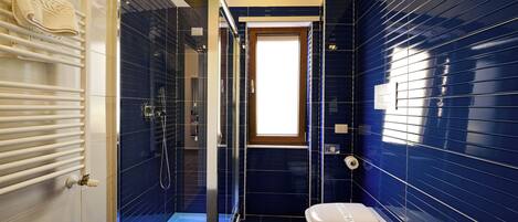 Un baño con cabina de ducha de vidrio, inodoro y bidé.