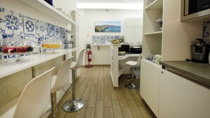 Een moderne keuken met witte kasten, een betegelde spatwand en een centraal eiland met barstoelen.