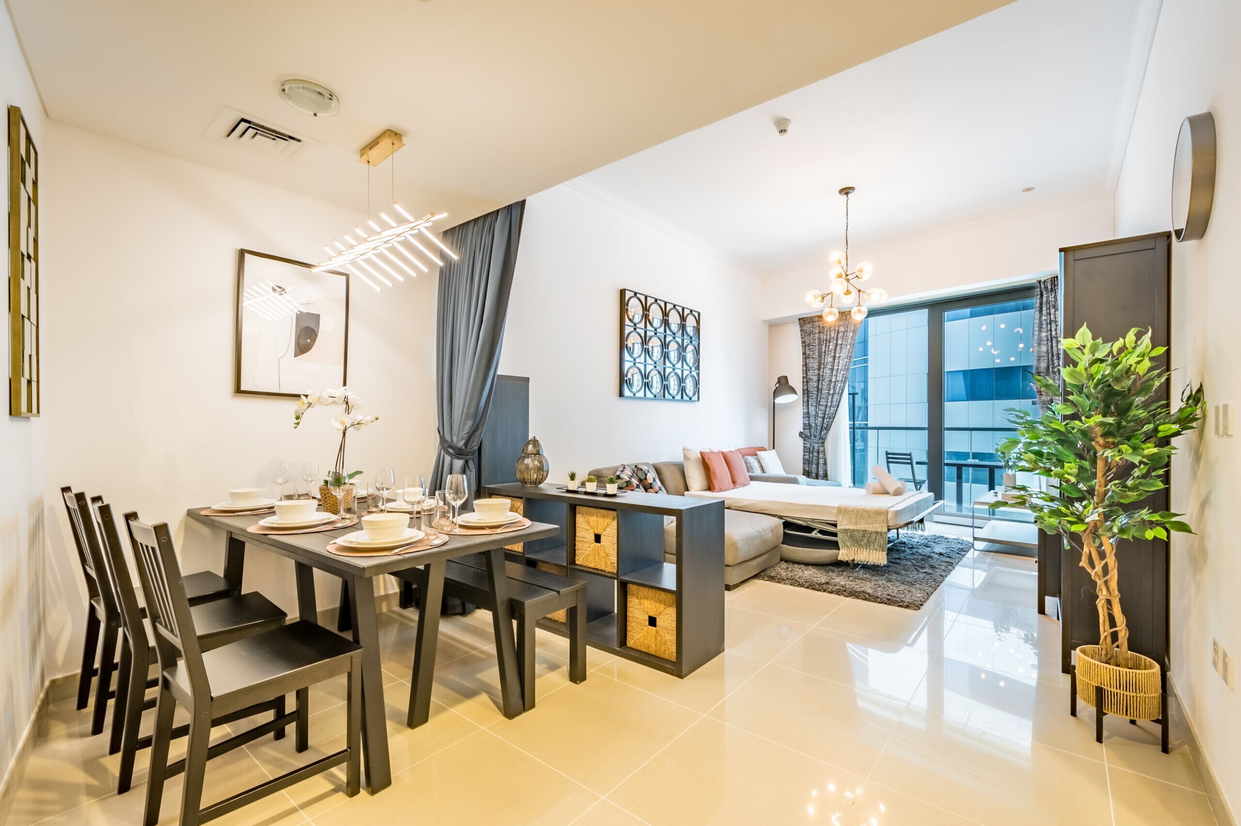 Una sala de estar moderna con comedor, un conjunto de sofás y un amplio ventanal con vistas al exterior.