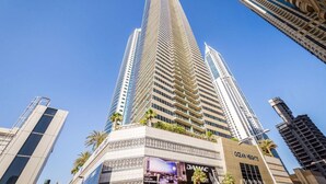 Un hôtel de grande hauteur au design moderne, doté d’une entrée imposante et d’une enseigne bien visible.