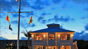 A two-story building with a flat roof and a balcony, featuring multiple windows and a central entrance. - Ocean Pointe Ocean View w/heated pool beach marina (Tavernier)