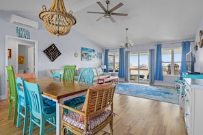 Relax in this inviting living area with a dining table, ceiling fan, and chandelier, offering a view of the outdoors.