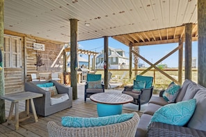 Relax in a welcoming outdoor space with a pergola overhead, wicker sofas, and a wooden table.