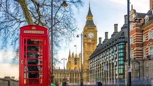 Une cabine téléphonique rouge et, au loin, la tour de l’horloge du Big Ben.